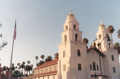Low angle view of palm trees and buildings against sky