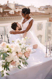 Happy couple embracing against townscape