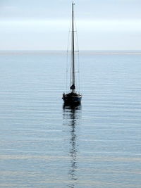 Sailboat sailing on sea against sky