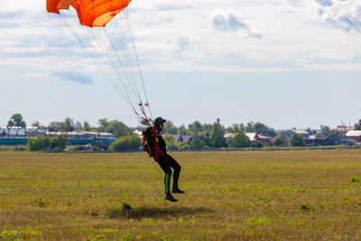 Low angle view of man paragliding against sky