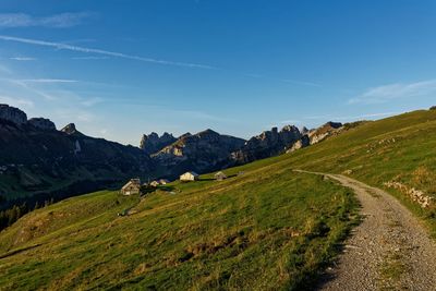 Scenic view of landscape and mountains against blue sky