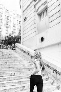 Woman standing by building in city