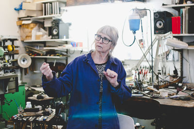 Senior female craftsperson working in jewelry workshop