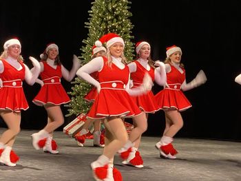 Rear view of people walking on red dancing against black background