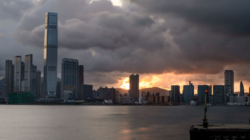 Modern buildings in city against sky during sunset