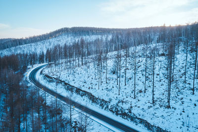 Scenic view of snow covered land against sky