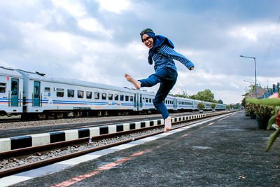 Man standing on railroad track against sky