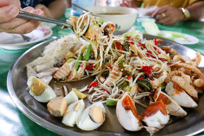 Close-up of hand holding food in plate