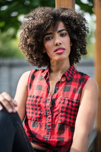 Portrait of young woman sitting on railing