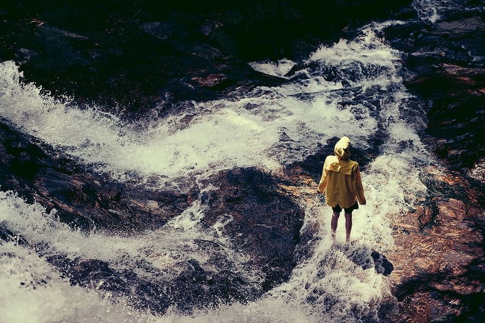 REAR VIEW OF WOMAN WALKING ON ROCK