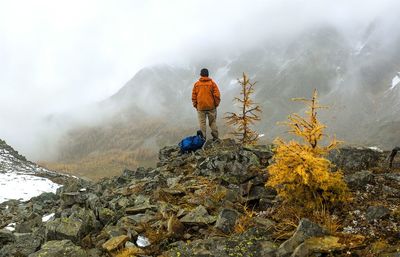 Rear view of man on mountain during foggy weather