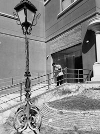 Man sitting on street against building