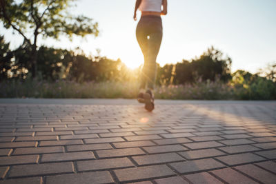 Low section of woman walking on street