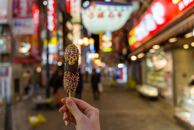 Close-up of hand holding illuminated lighting equipment at night