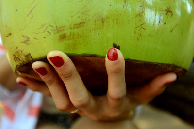 Cropped image of woman hand holding coconut