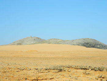 Scenic view of desert against clear blue sky