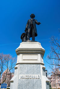 Low angle view of statue against blue sky