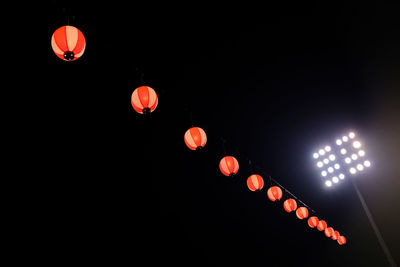 Low angle view of illuminated lanterns hanging at night