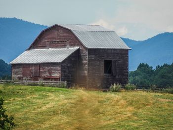 Abandoned house on field against sky