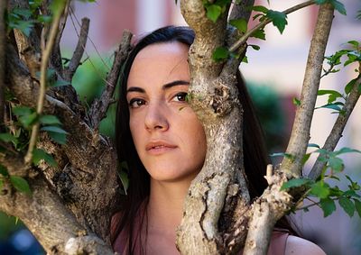 Portrait of young woman looking tree