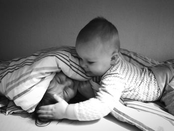 Close-up of children playing on bed at home