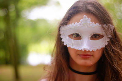 Close-up portrait of young woman wearing venetian mask