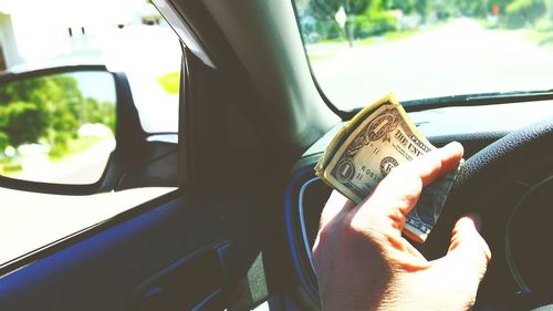 Close-up of hand holding car window