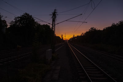 Railroad tracks against sky during sunset