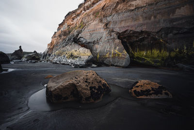 Rocks on beach against sky