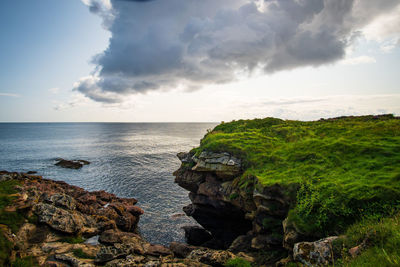 Rock formations by sea against sky