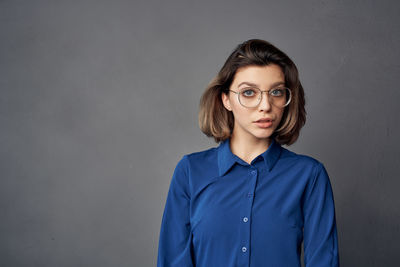 Portrait of beautiful young woman against blue background