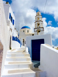 Low angle view of staircase amidst buildings against sky