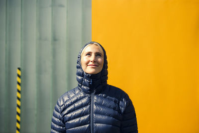 Portrait of woman standing against wall