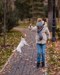 Side view of woman with dog on footpath