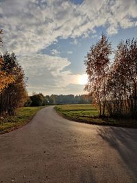 Road amidst trees against sky