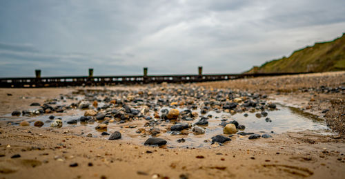 View of pebbles on beach against sky