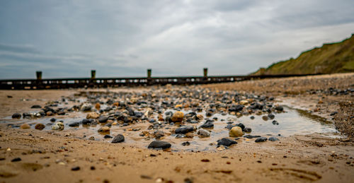 View of pebbles on beach against sky