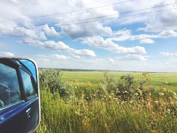 Scenic view of field against cloudy sky