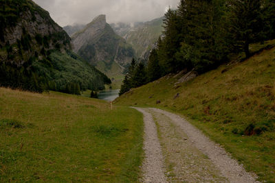 Road leading towards mountains against sky
