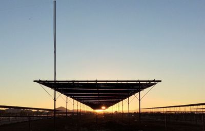 Illuminated bridge against clear sky during sunset