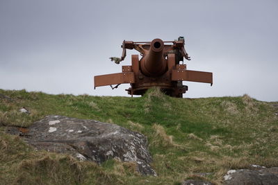 Cannon on landscape against clear sky