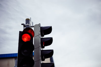 Low angle view of road signal against sky