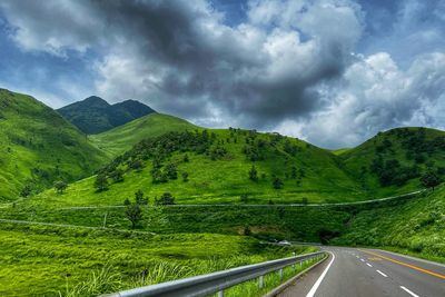 Road leading towards mountains against sky