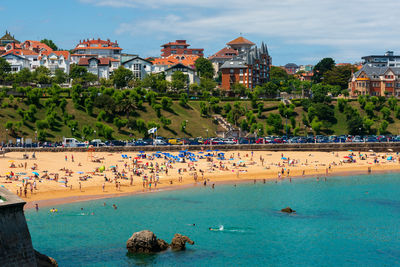 Buildings by sea against sky