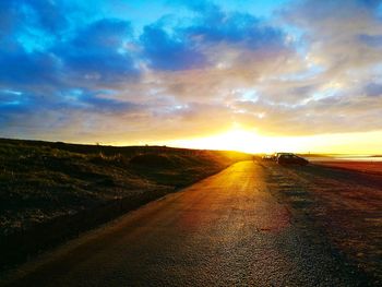 Road amidst landscape against sky during sunset