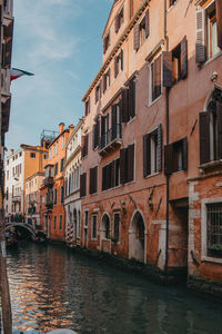 Canal amidst buildings against sky