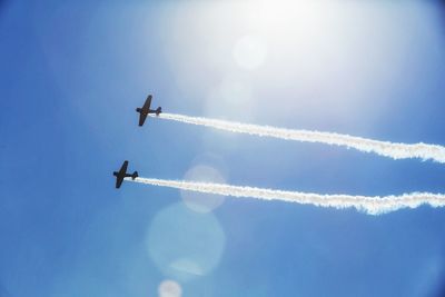 Low angle view of airplane flying against blue sky