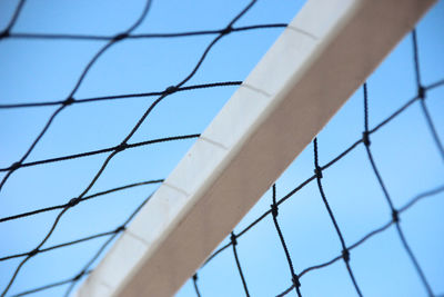 Low angle view of fence against blue sky