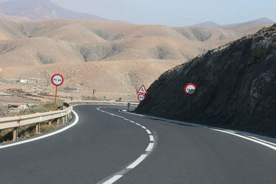 Road leading towards mountains against sky