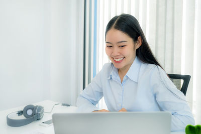 Portrait of a smiling young woman using smart phone